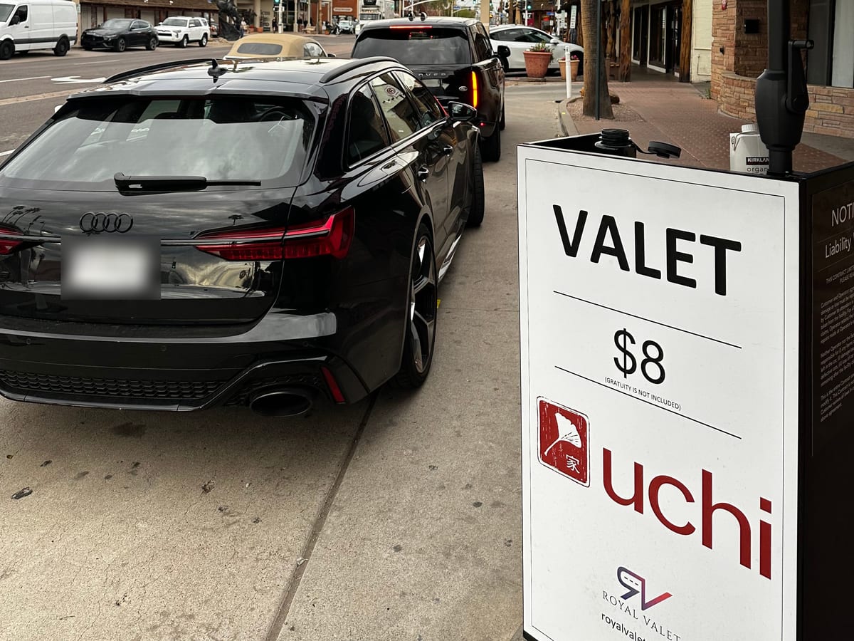 A Royal Valet stand co-branded with Uchi in Old Town Scottsdale, a guest’s Audi at the curb