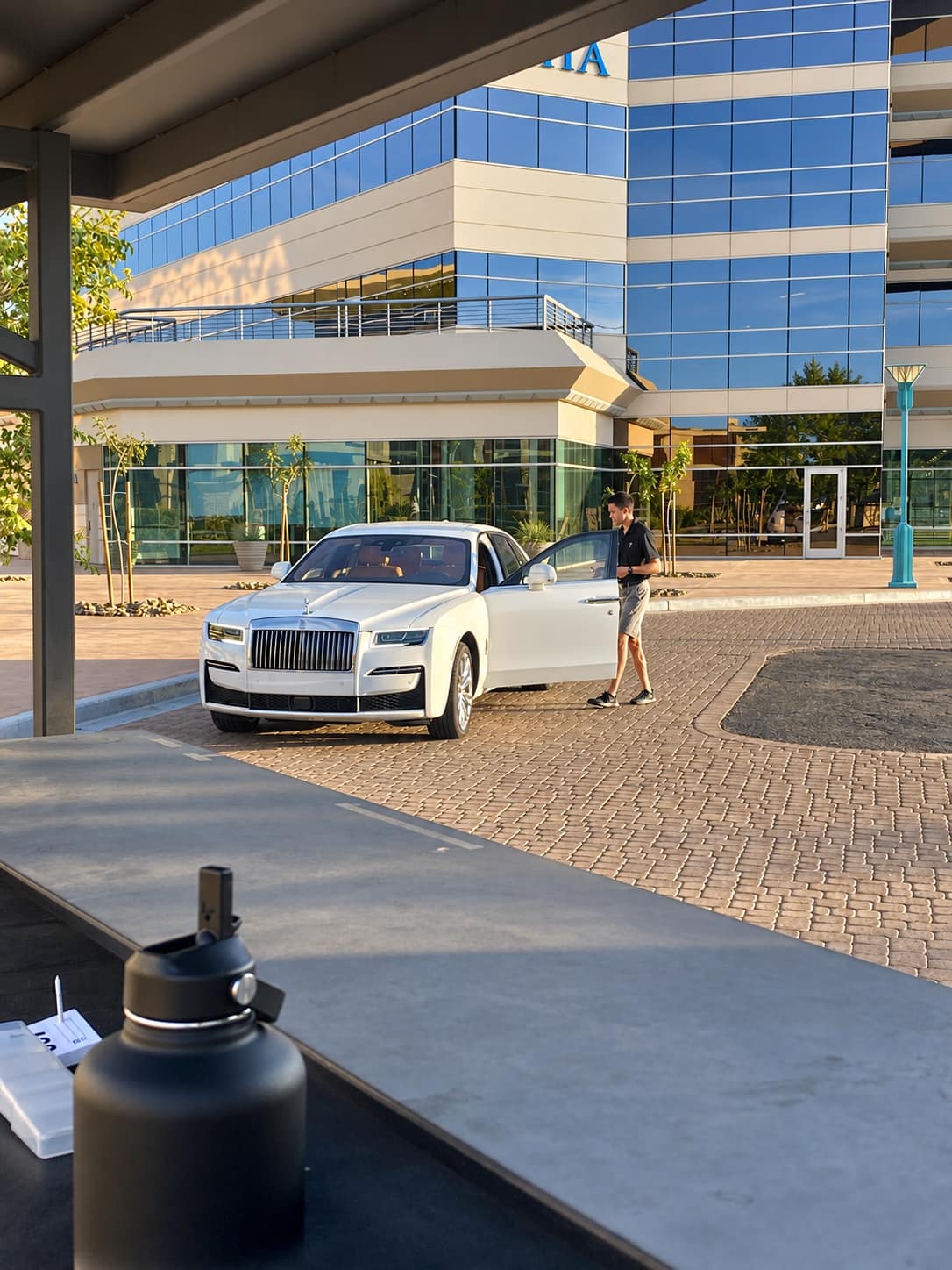 Royal Valet attendant opening the door of a white Rolls-Royce