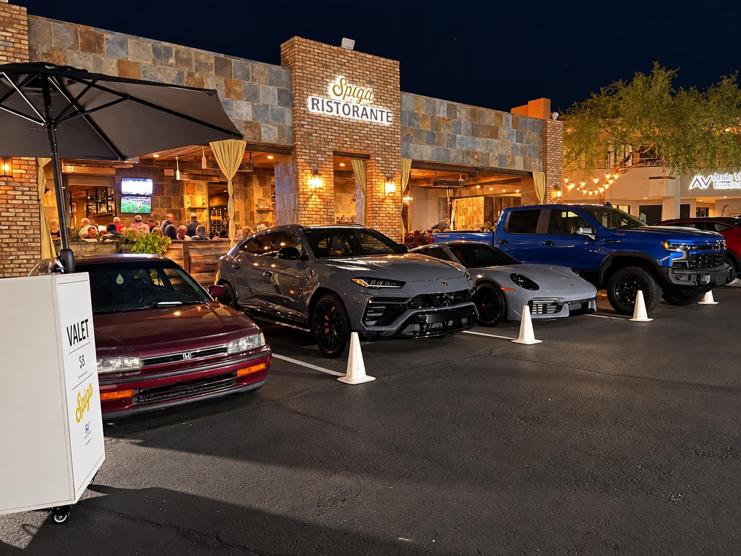 Guests’ cars lined up at the valet stand outside Spiga Ristorante at night