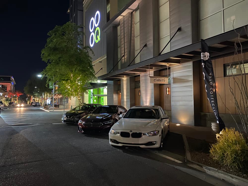 Cars parked by valet outside a Scottsdale Quarter building at night